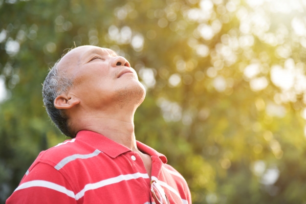 Photo of a senior person taking in a breath of fresh air.