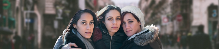 A family of three Hispanic woman holding each other.