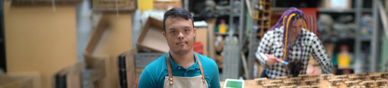 Image of a young man with a disability working in a warehouse.