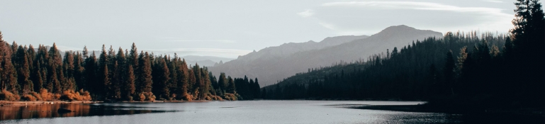 A photo of a beautiful lake with mountains in the background. The image is calming