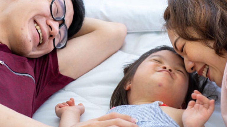 A you husband and wife with their new adopted daughter who has a disability.