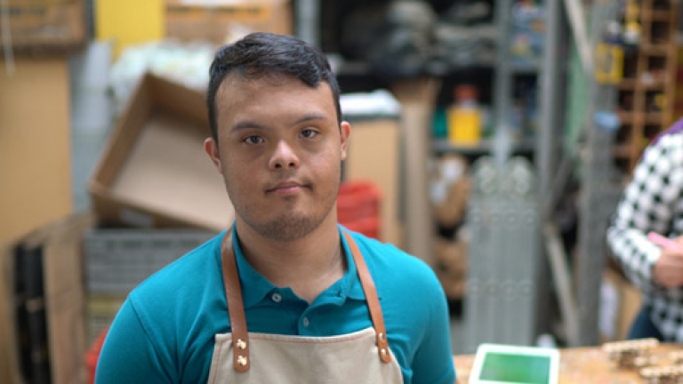 Image of a young man with a disability working in a warehouse.