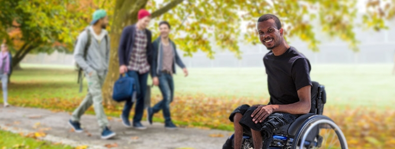 Photo of a young man in a wheelchair at a collage campus.