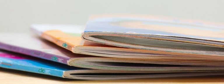 Several publications spread out laying on a table.